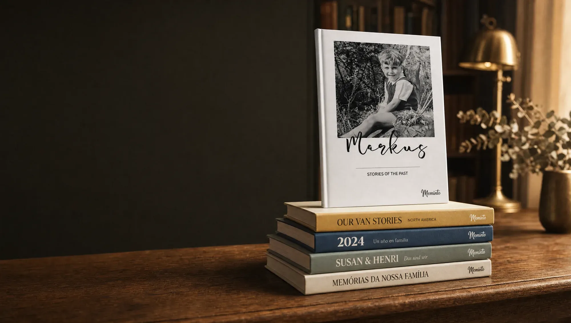 A stack of real Meminto memory books in English, German, Spanish and Portuguese on a warm wooden table